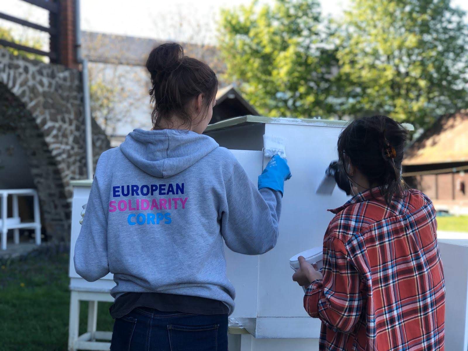 Two person standing next to each other before a flipchart.